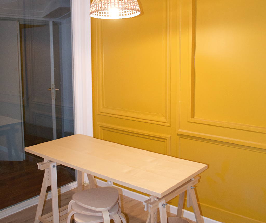 Un de nos bureaux privatifs, peinture jaune avant table haute au centre